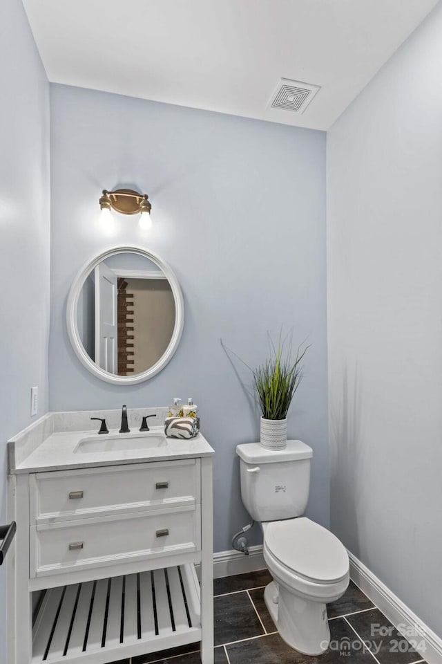 bathroom featuring vanity, hardwood / wood-style flooring, and toilet