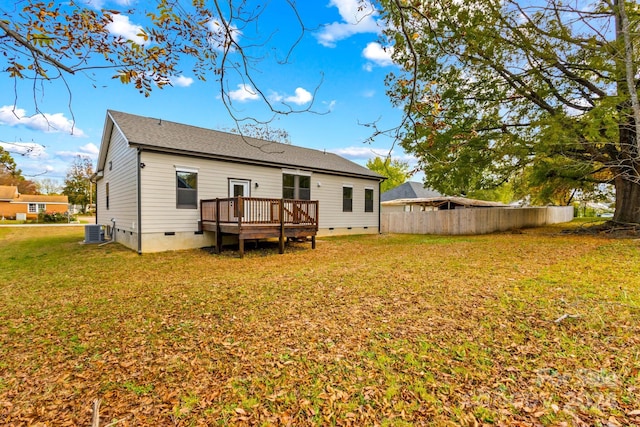 back of property with central air condition unit, a wooden deck, and a lawn