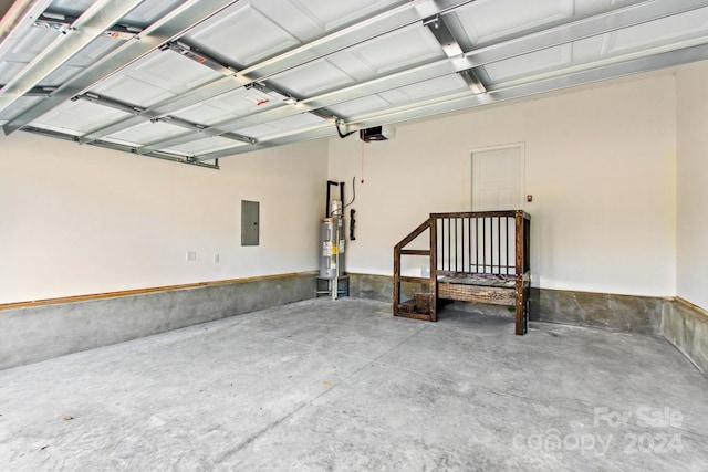 garage with electric panel, a garage door opener, and electric water heater