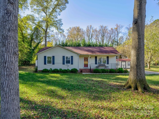 ranch-style home featuring covered porch and a front lawn