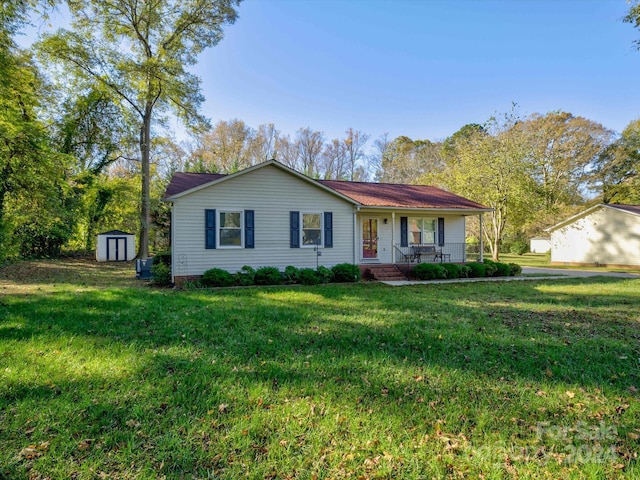 ranch-style house with a front lawn, a porch, and a storage shed