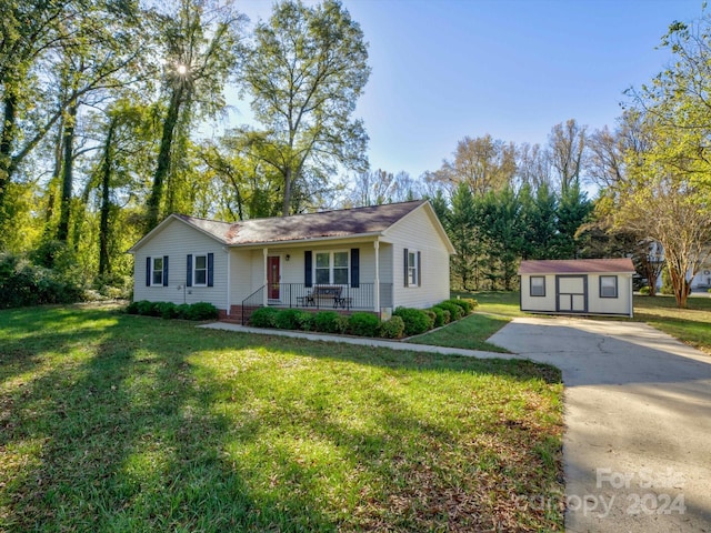 single story home featuring covered porch, a shed, and a front yard