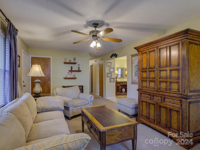 living room featuring a textured ceiling, ceiling fan, and light carpet