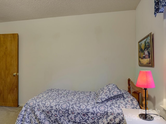 bedroom with light carpet and a textured ceiling