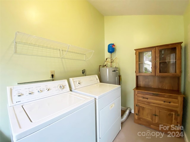 clothes washing area with washer and clothes dryer and water heater