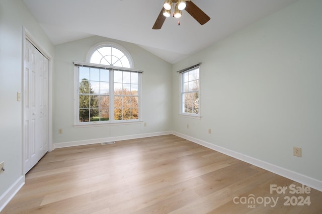 unfurnished bedroom featuring ceiling fan, lofted ceiling, and multiple windows