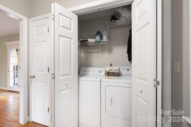 laundry room with washer and clothes dryer and light hardwood / wood-style floors