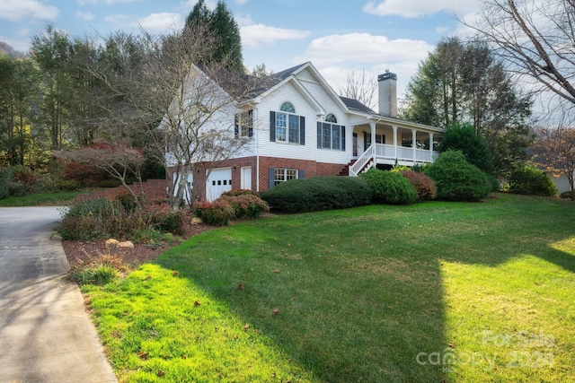 view of front facade featuring covered porch, a garage, and a front lawn