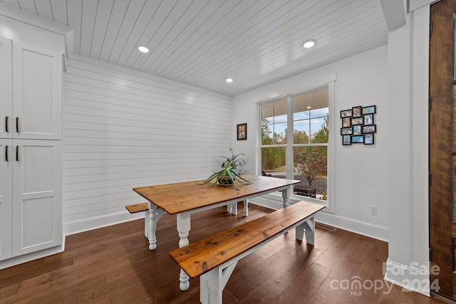 dining area featuring wood walls and dark hardwood / wood-style flooring