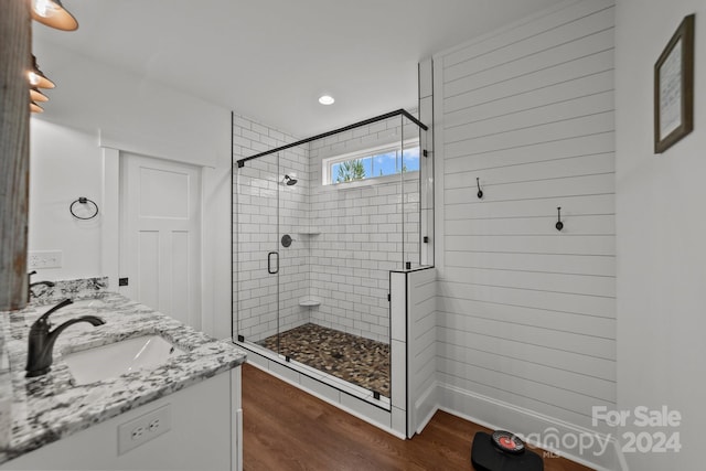 bathroom featuring walk in shower, wood-type flooring, and vanity