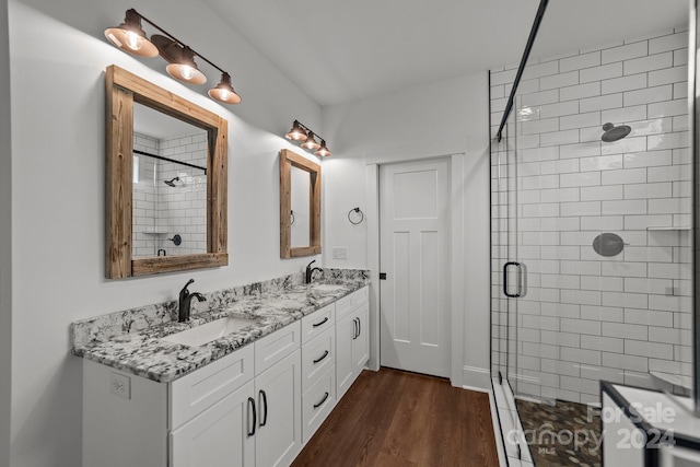 bathroom featuring vanity, hardwood / wood-style flooring, and a shower with door