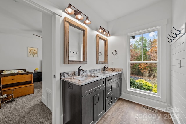 bathroom with hardwood / wood-style flooring, ceiling fan, and vanity