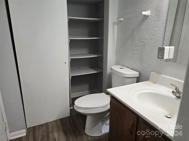 bathroom with hardwood / wood-style flooring, vanity, and toilet