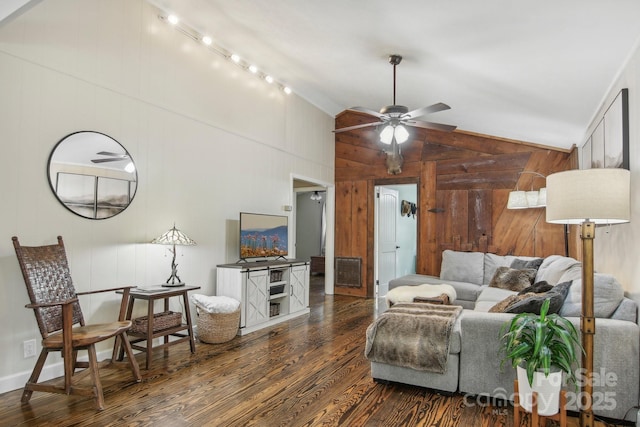 living room with wooden walls, ceiling fan, dark wood-type flooring, and vaulted ceiling