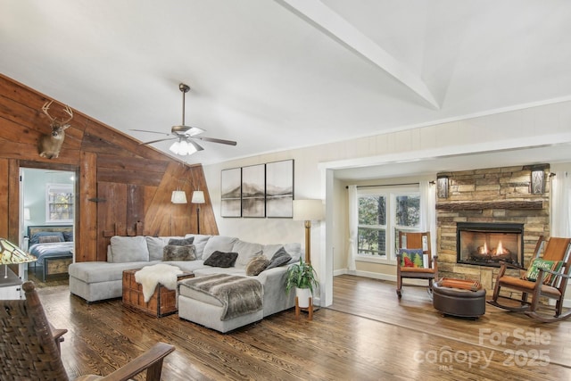 living room with ceiling fan, wooden walls, a fireplace, dark hardwood / wood-style floors, and lofted ceiling