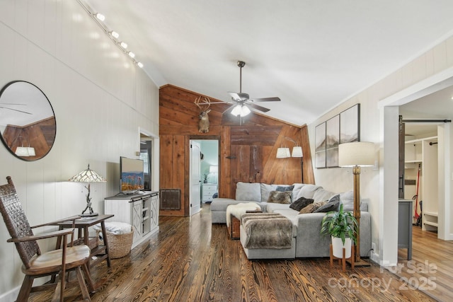 living room with wooden walls, ceiling fan, dark hardwood / wood-style floors, and lofted ceiling