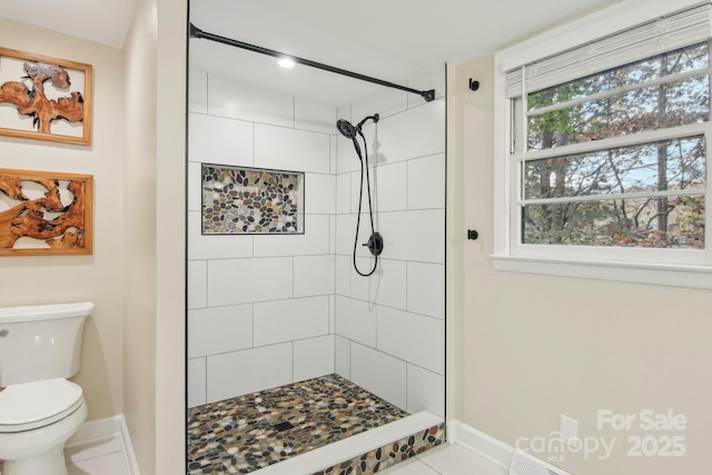 bathroom featuring toilet and a tile shower