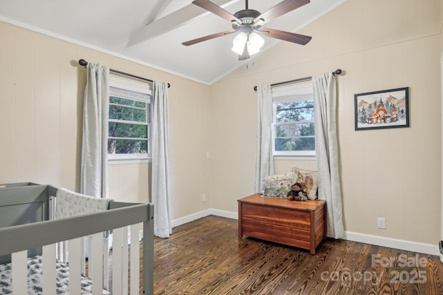 bedroom featuring dark wood-type flooring, crown molding, vaulted ceiling, ceiling fan, and a nursery area