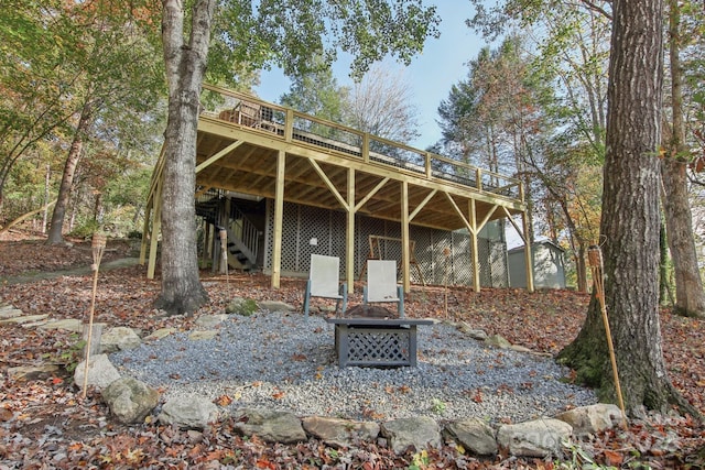 rear view of property with a deck and an outdoor fire pit