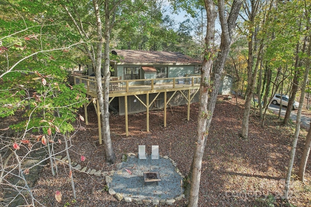 rear view of house featuring a wooden deck and an outdoor fire pit