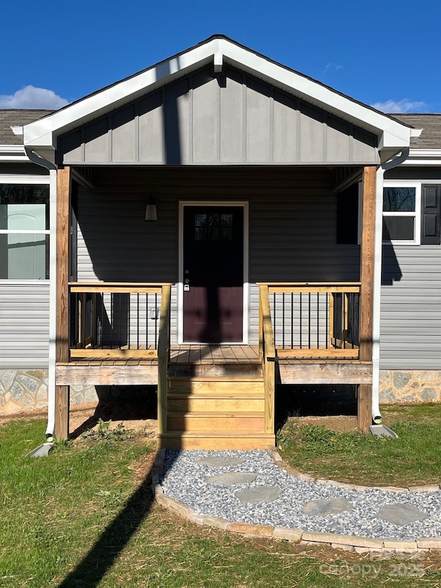 exterior space featuring covered porch, a shingled roof, and board and batten siding