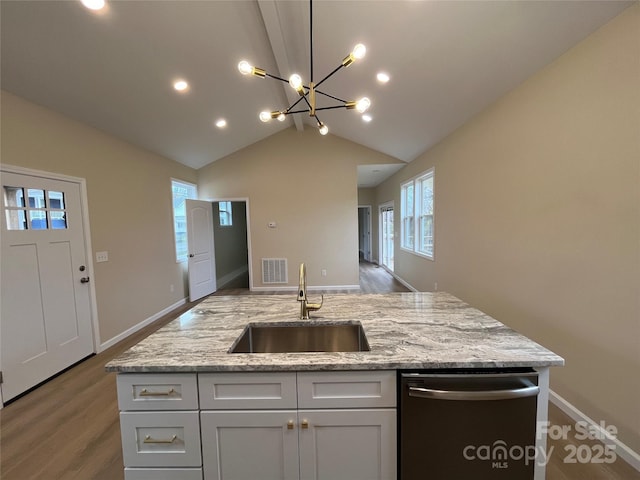 kitchen with sink, vaulted ceiling, stainless steel dishwasher, and light stone countertops