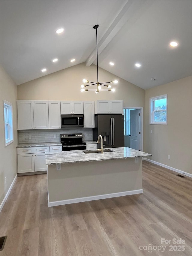 kitchen featuring stainless steel appliances, light stone countertops, decorative backsplash, and white cabinets