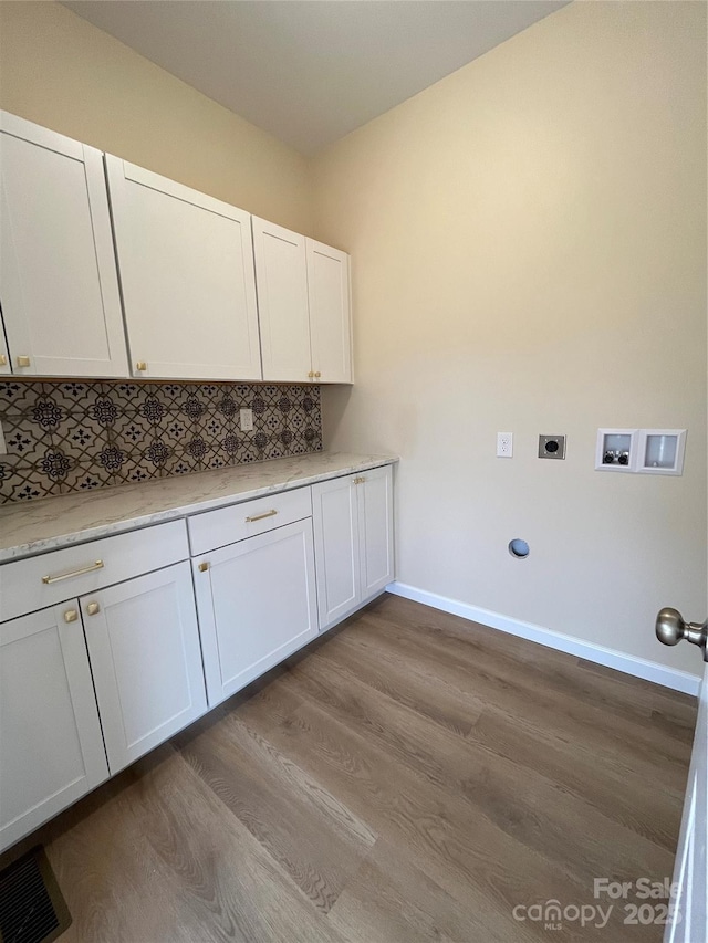 laundry area featuring hookup for a washing machine, visible vents, cabinet space, electric dryer hookup, and light wood-type flooring