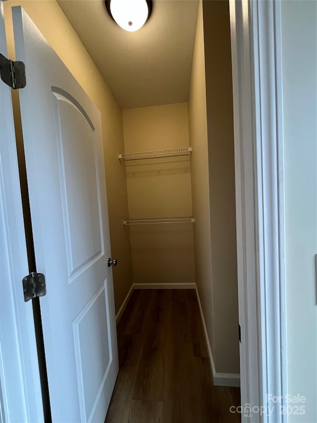 hall with dark wood-style floors and baseboards