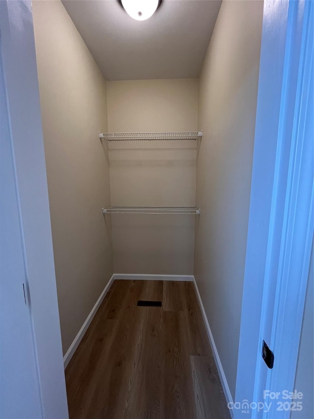 walk in closet featuring dark wood finished floors