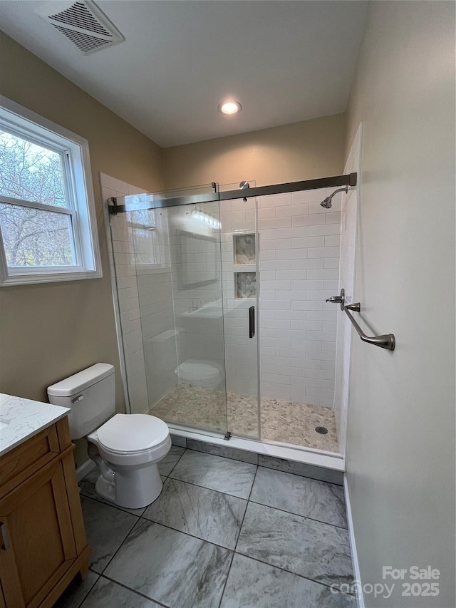 bathroom with marble finish floor, visible vents, toilet, vanity, and a shower stall