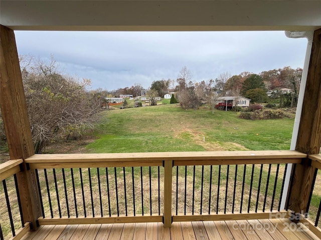 wooden terrace featuring a lawn