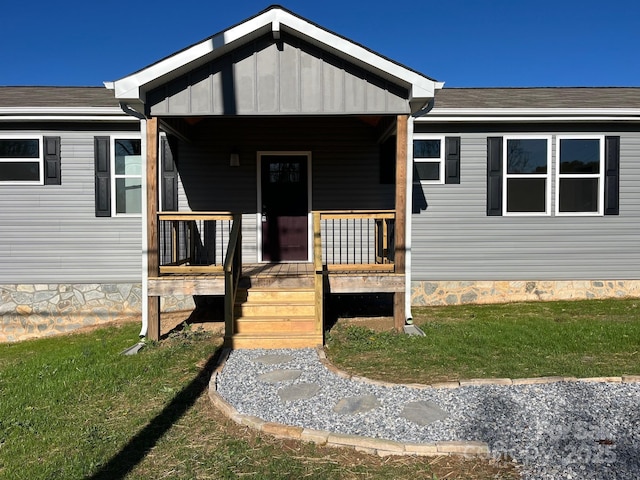 doorway to property featuring a yard and board and batten siding