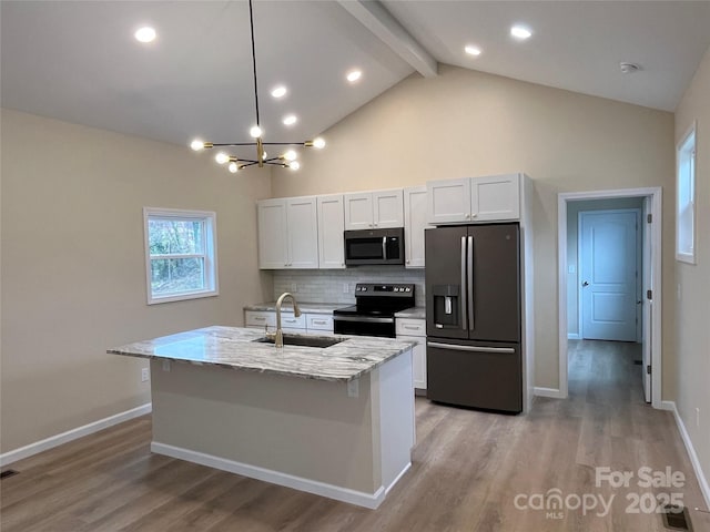 kitchen featuring a kitchen island with sink, stainless steel appliances, and white cabinetry