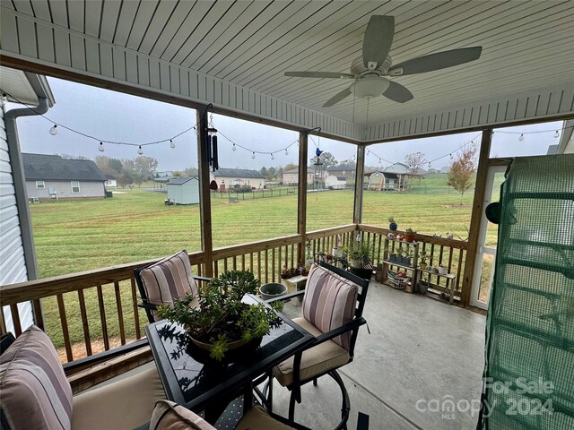 sunroom / solarium featuring a wealth of natural light, ceiling fan, and wood ceiling