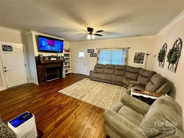 living room featuring ceiling fan, a textured ceiling, dark hardwood / wood-style flooring, and crown molding