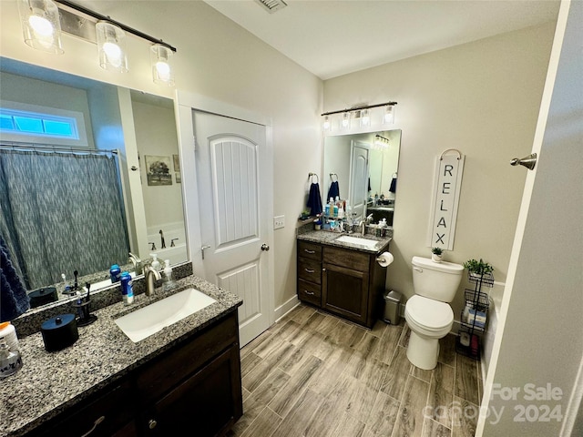 bathroom featuring hardwood / wood-style flooring, vanity, toilet, and walk in shower