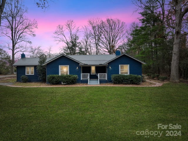 single story home with a yard and covered porch