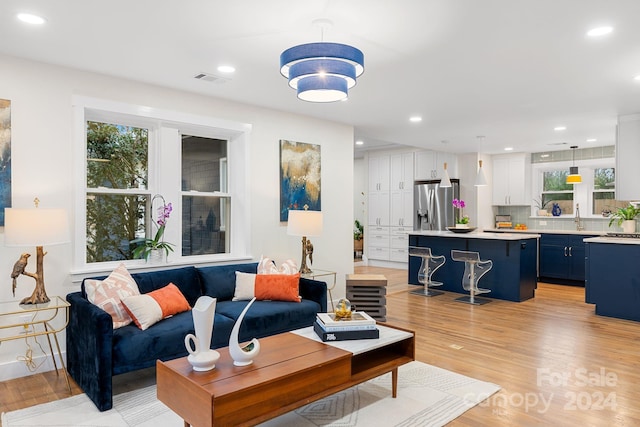 living room with light hardwood / wood-style floors and sink