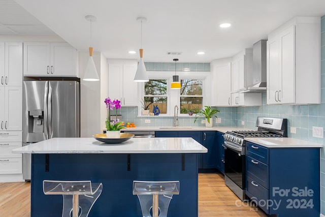 kitchen with a center island, sink, wall chimney range hood, and stainless steel appliances