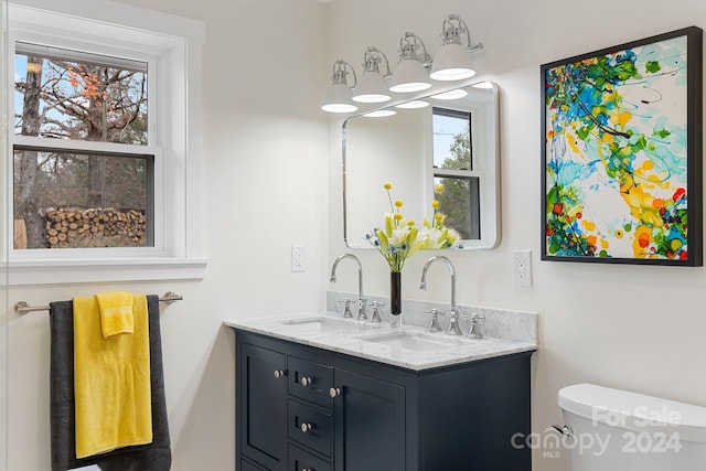 bathroom with vanity, a healthy amount of sunlight, and toilet