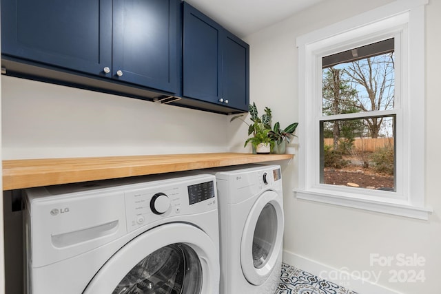 laundry area with cabinets, tile patterned floors, and washer and dryer