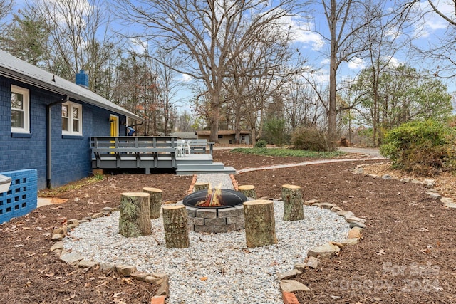 view of yard with an outdoor fire pit and a wooden deck