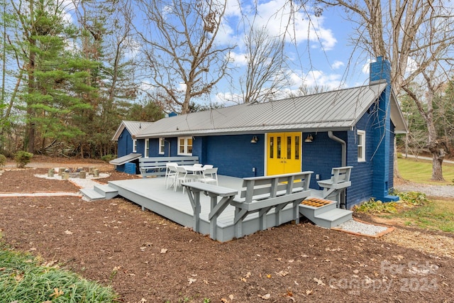 back of house featuring a wooden deck and french doors