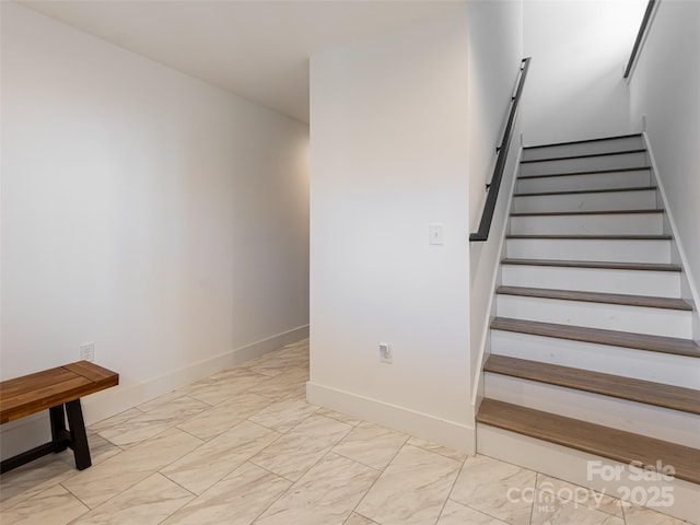 stairs featuring marble finish floor and baseboards