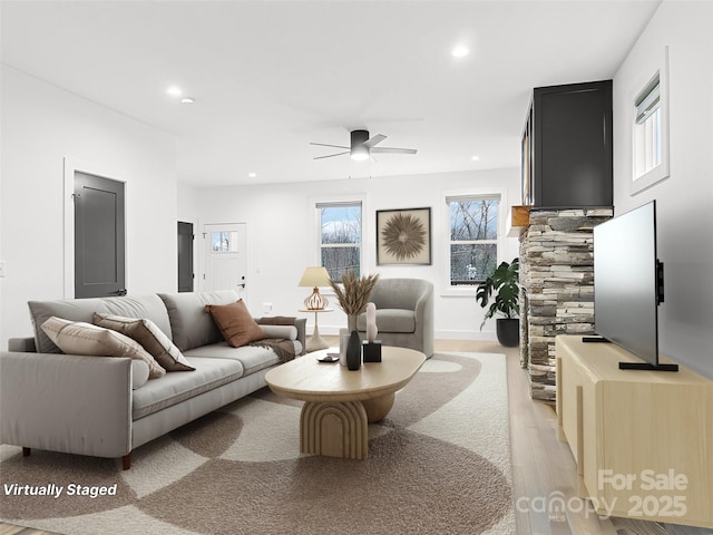 living area featuring light wood-style floors, a ceiling fan, and recessed lighting