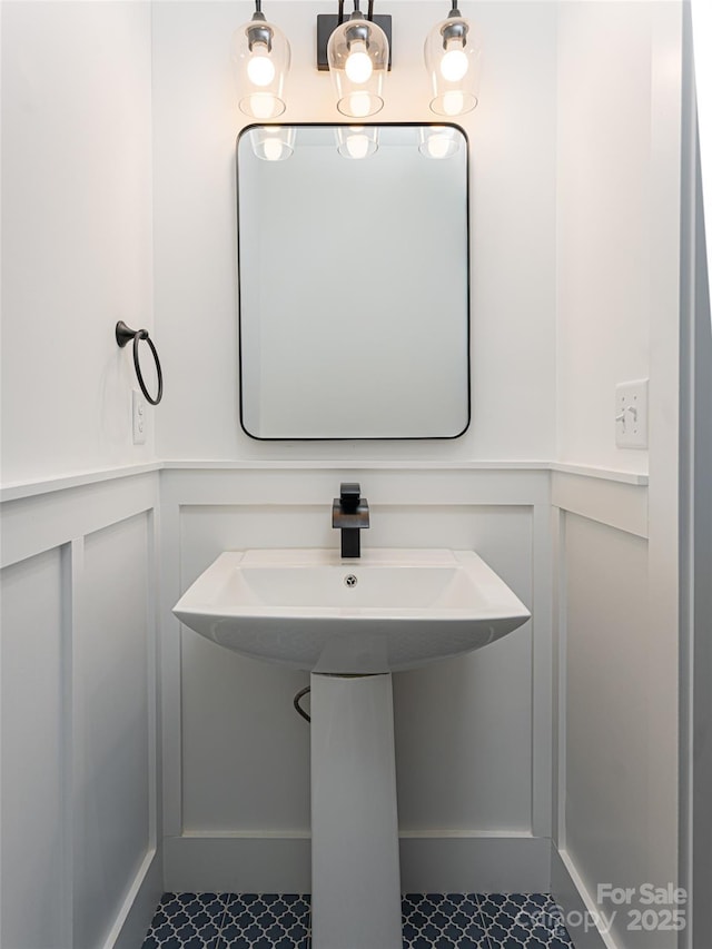 bathroom featuring a wainscoted wall and a decorative wall