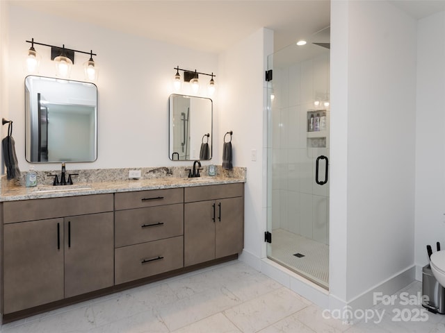 full bath featuring marble finish floor, a stall shower, a sink, and baseboards