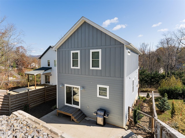 rear view of property with fence and board and batten siding