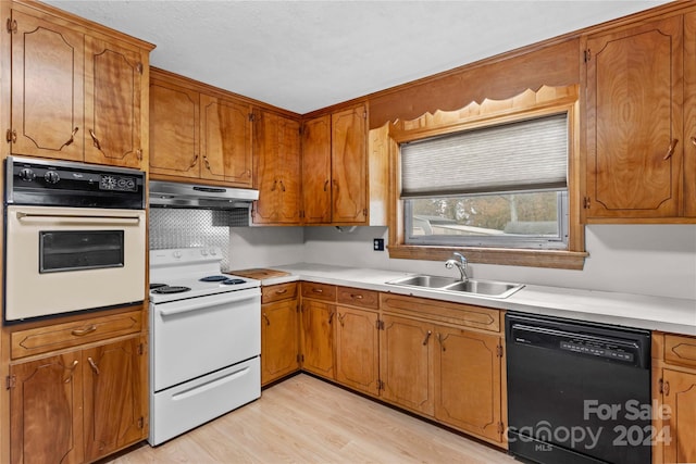 kitchen featuring white appliances, sink, and light hardwood / wood-style flooring